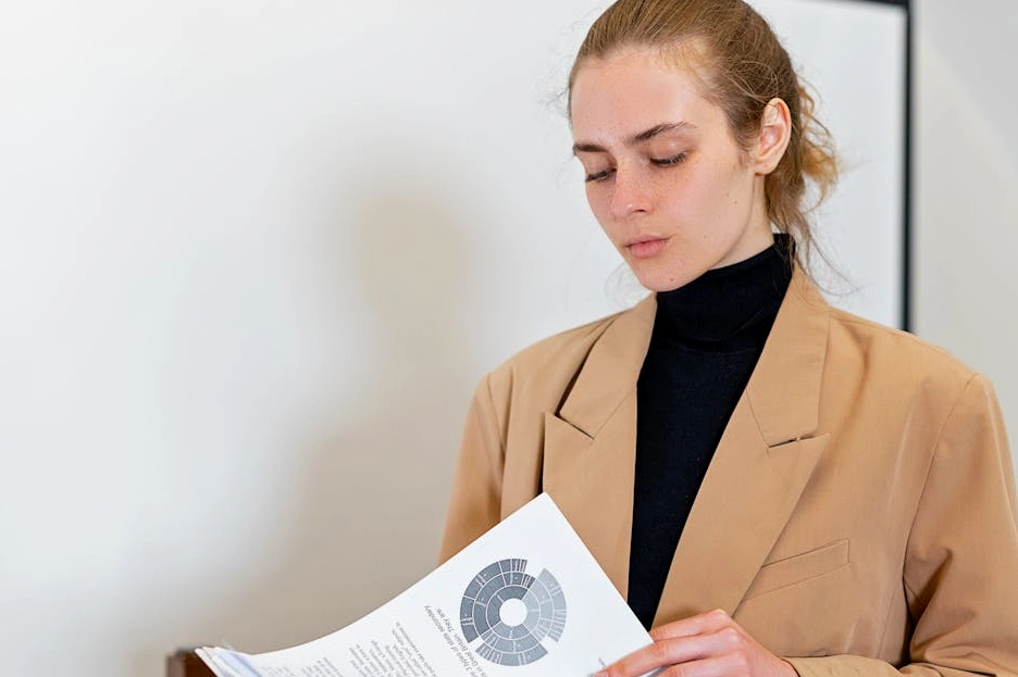 Persona che legge un report su un tablet in un ufficio moderno.